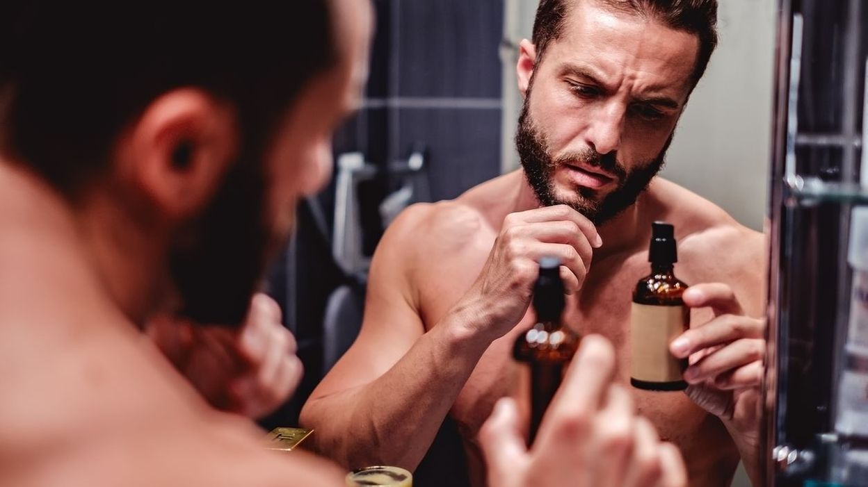 homme avec une barbe devant son miroir